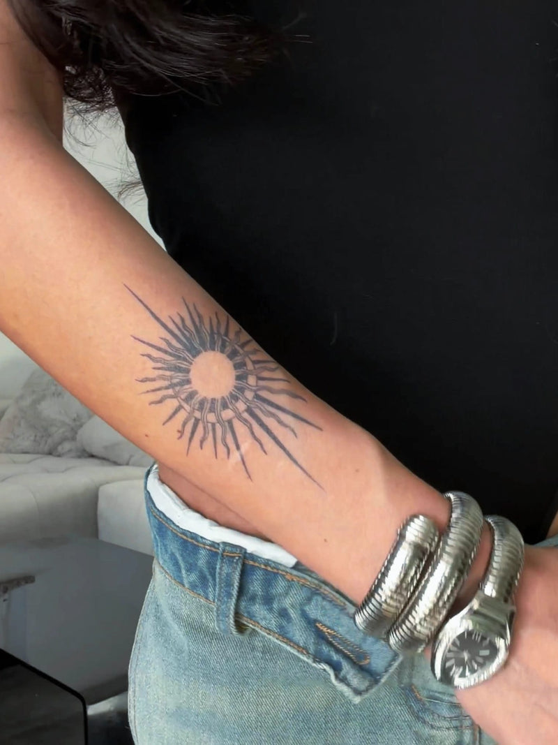 Tattup 2-Wochen-Tattoo einer Sonne auf dem Unterarm einer Frau
