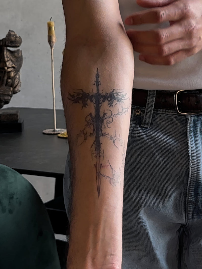Fine-Line-Dolch-Tattoo am Unterarm, als Test vor einem echten Tattoo getragen